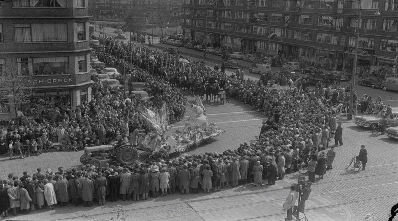 Publiek kijkt toe bij een bevrijdingsoptocht door de Stadhoudersweg, 1955