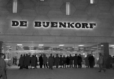 Omstanders kijken toe hoe burgemeester Van Walsum warenhuis De Bijenkorf opent, 1957